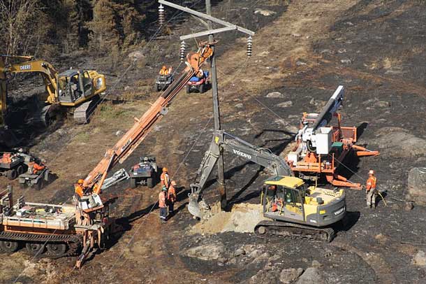 Hydro One crews work to rebuild 80 transmission structures damaged by a forest fire in northwest Ontario