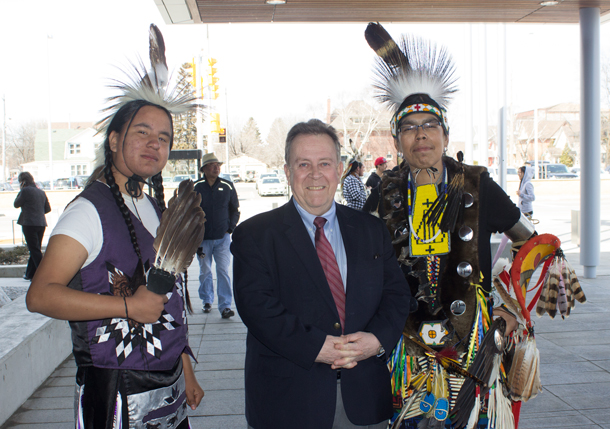 Minister Michael Gravelle with Munzeroy and another of the Dancers in their colourful regalia