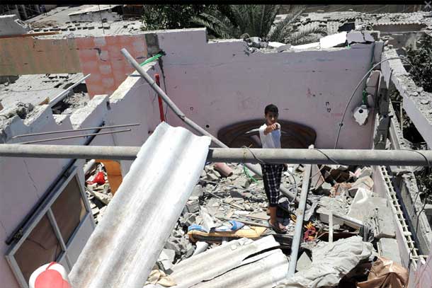 A young boy stands in the ruins of a house which was destroyed during an air strike in Central Bureij refugee camp in the Gaza Strip. Photo: UNRWA