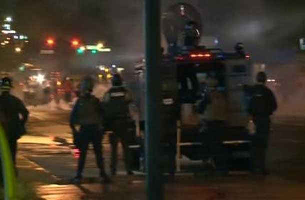 Police advance behind armed vehicle in Ferguson Missouri as another violent night goes by.