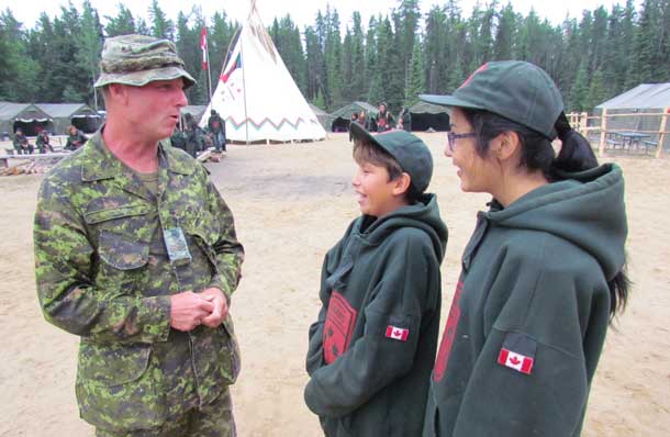 Sergeant James Doherty talks with Junior Canadian Rangers at a Junior Ranger camp.