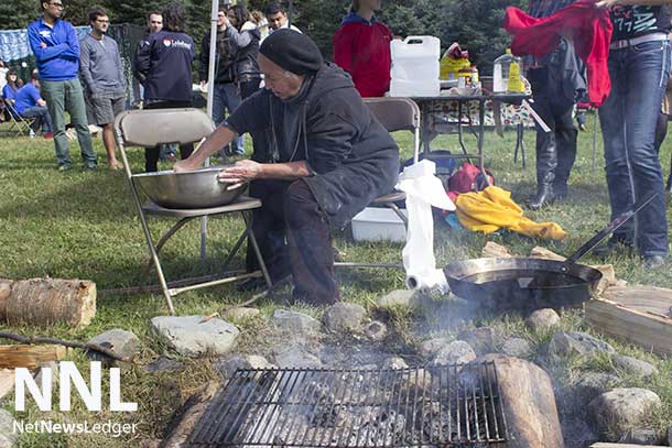 Sara Sabourin making bannock over the open fire at Lakehead University