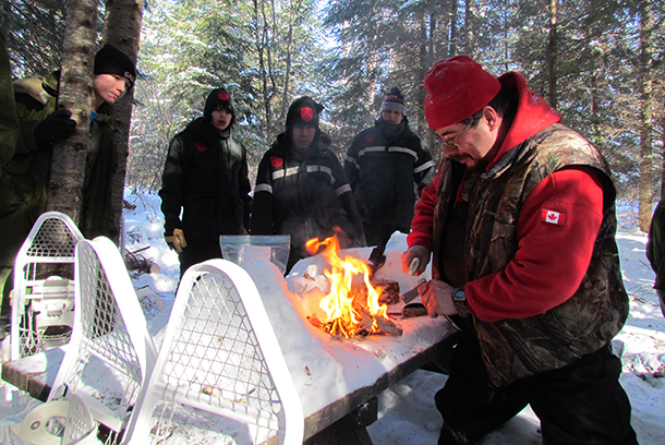 Ranger Master Corporal Michael Pelletier demonstrates how to use a knife and flint to start a fire.