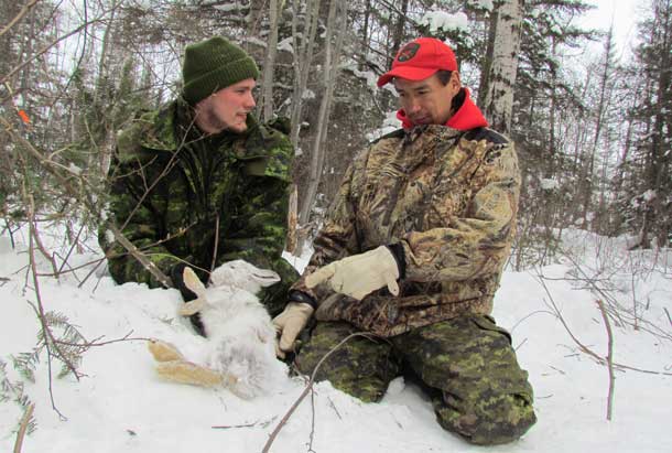 Private Zachary Bangs of Timmins talks with Canadian Ranger Jimmy Wynne about using snares to catch rabbits