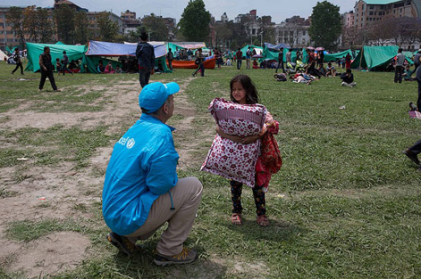 A UNICEF worker speaks to a child seeking temporary shelter at a vacant field next to Nepal's army headquarters in Kathmandu following Nepal's massive earthquake. Photo: UNICEF/NYHQ2015-1007/Nybo