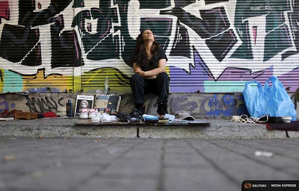 A street vendor in Athens sits behind her wares - REUTERS / Christian Hartmann