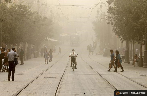 A cyclist rides with a covered face during a sandstorm in Jerusalem September 8, 2015. A heavy sandstorm swept across parts of the Middle East on Tuesday, killing two people and hospitalising hundreds in Lebanon and disrupting fighting and air strikes in neighbouring Syria.Clouds of dust also engulfed Israel, Jordan and Cyprus where aircraft were diverted to Paphos from Larnaca airport as visibility fell to 500 metres. REUTERS/Ammar Awad