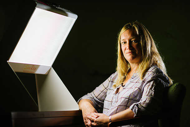 Talk outshines light in keeping the winter blues at bay, University of Vermont researcher Kelly Rohan found in a study to be published in the American Journal of Psychiatry. Two winters after the initial treatment, 46 percent of research subjects given light therapy reported a recurrence of depression compared with 27 percent of those who were administered CBT. Depressive symptoms were also more severe for those who received light therapy. Rohan is pictured with a light box used in light therapy. CREDIT Andy Duback