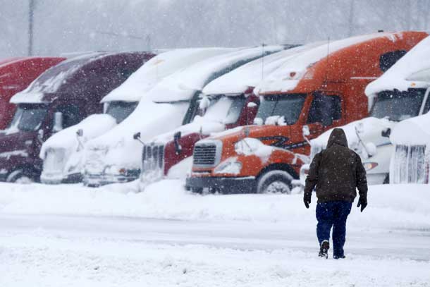 A man walks toward freight trucks waiting out a winter storm at a truck stop near Trenton, New Jersey, January 23, 2016. REUTERS/Dominick Reuter