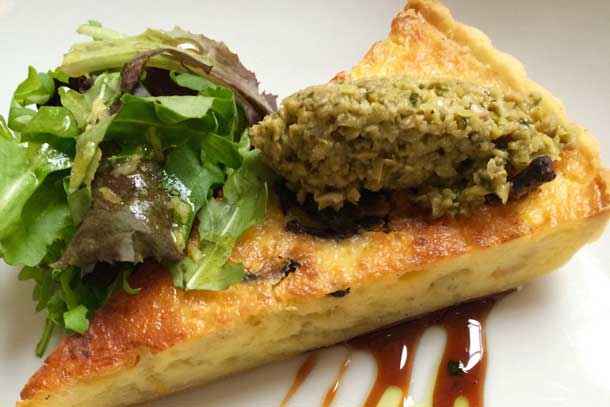 A quiche made from tofu and scallions with tapenade and greens. Credit: Copyright 2015 Kathy Hunt