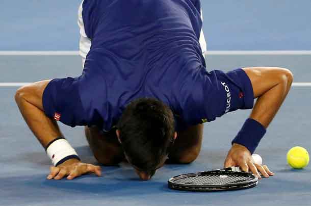 Serbia's Novak Djokovic kisses the court as he celebrates after winning his final match against Britain's Andy Murray at the Australian Open tennis tournament at Melbourne Park, Australia, January 31, 2016. REUTERS/Issei Kato