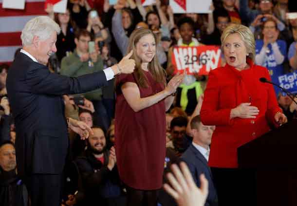 Bill Clinton gives his wife a thumbs up as they celebrate with their daughter Chelsea at her caucus night rally in Des Moines. REUTERS/Brian Snyder
