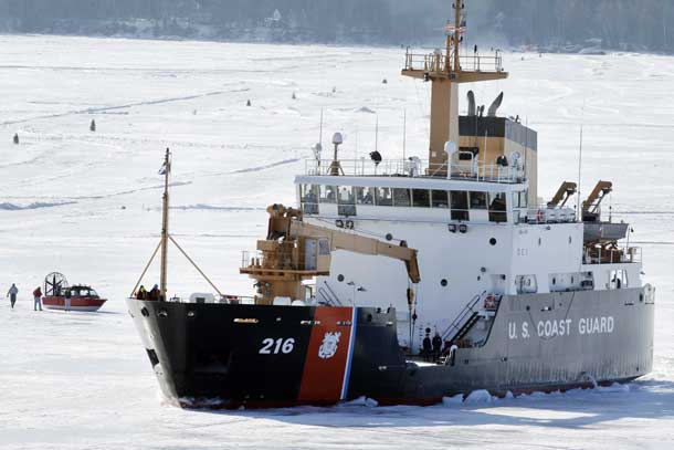 STANDALONE PHOTO -- The U.S. Coast Guard cutter Alder breaks ice near a windsled Wednesday, April 3, 2013 near the harbor in Bayfield, Wis. on Lake Superior. The Madeline Island ferry plans to resume running on Friday. Most traffic across Lake Superior between Bayfield and Madeline Island is either via the ferry or, in the depths of winter, the ice road. But when the ice is either breaking up or settling into its winter thickness, people can get across only by the wind sled - an enclosed boat-hulled craft with huge fans on the back that push the vehicle across the shifting ice.. The wind sleds are usually in action for 10 to 14 days at the beginning of winter and about a week in the spring, though the duration varies each year. MARK HOFFMAN/MHOFFMAN@JOURNALSENTINEL.COM