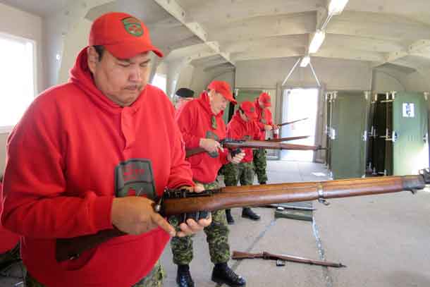 Ranger Alex Barkman of Sachigo Lake, left, and other Rangers learn how to handle the .303 calibre Lee-Enfield rifle safely.