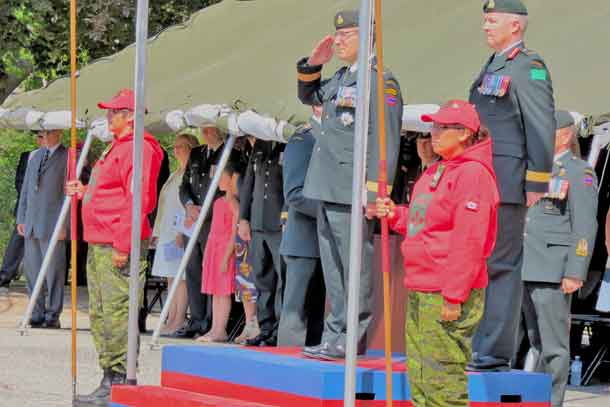 Corporal Rita Brisket and Master Corporal Ningewance flank Lieutenant-General Marquis Hainse, commander of the Canadian Army, as he takes a salute from the guard of honour.