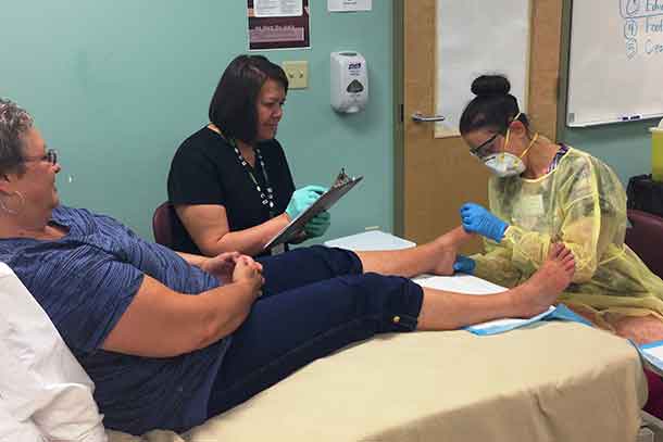 Foot Care Nurse students Brette Cain (right) and Wendy Sandberg, examine client Sonia Rutter’s feet during a free clinic held at Confederation College.