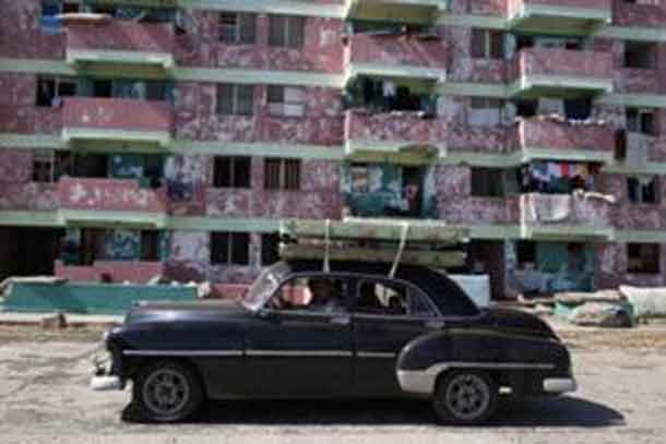 People transport beds on the roof of a vintage car in Baracoa. REUTERS/Alexandre Meneghini