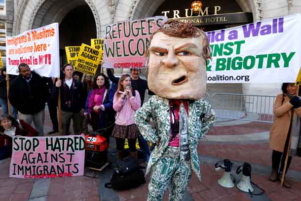A demonstrator dresses in a Trump costume as people gather to protest against Republican U.S. presidential nominee Donald Trump on the sidewalk, outside the grand opening of his new Trump International Hotel in Washington, U.S. October 26, 2016. REUTERS/Jonathan Ernst