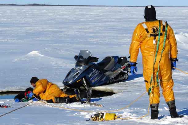 Canadian Rangers find and rescue a snowmobiler who has gone through the ice in a mock incident during a search and rescue exercise