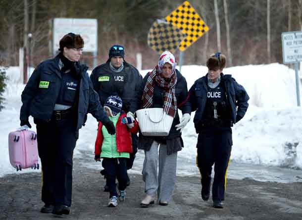 A family that claimed to be from Turkey are met by Royal Canadian Mounted Police (RCMP) officers after they crossed the U.S.-Canada border illegally leading into Hemmingford, Quebec Canada March 20, 2017.  REUTERS/Christinne Muschi