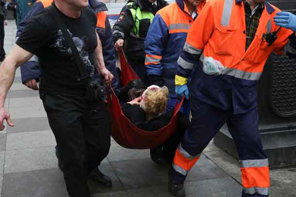 An injured person is helped by emergency services outside Sennaya Ploshchad metro station, following explosions in two train carriages at metro stations in St. Petersburg, Russia April 3, 2017. REUTERS/Anton Vaganov