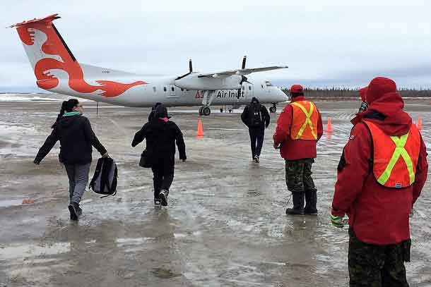 Canadian Rangers guide evacuees to plane at Kashechwan airport.