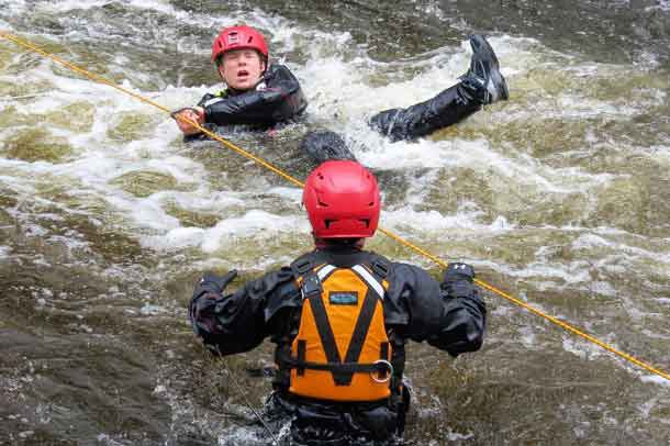 Leading Seaman Christina Gillis clutches a carabiner clip attached to a rescue rope during swift water rescue training