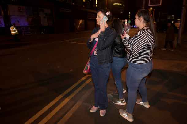 Concert goers react after fleeing the Manchester Arena in northern England where U.S. singer Ariana Grande had been performing in Manchester, Britain, May 22, 2017. REUTERS/Jon Super