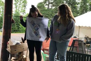 Companion Janessa (left) with camper Jacklyn presenting their house flag – The Hairy House.