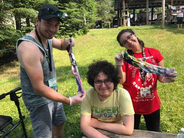 Companion Joe (left) with Camper Brendan and Companion Maddie holding up their tie-dye creation!