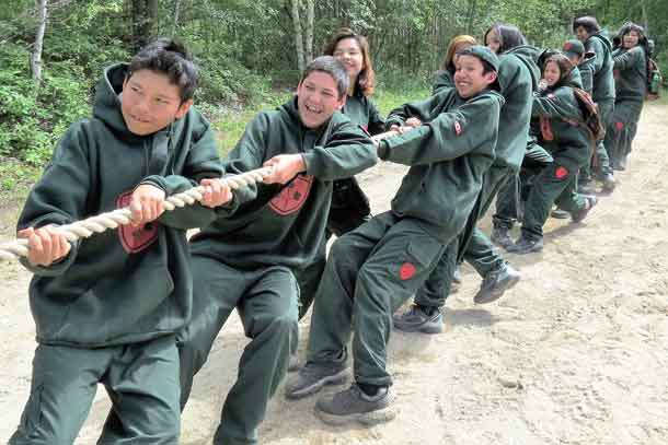 Junior Canadian Rangers winning a tug of war contest against soldiers.