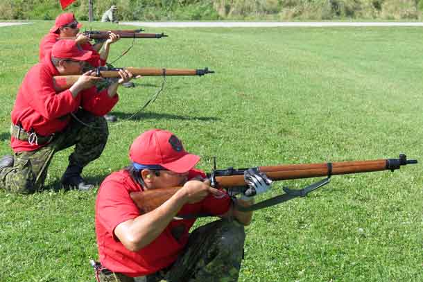 Master Corporal Darren Shewaybick of Webequie, right,shoots in a kneeling position.