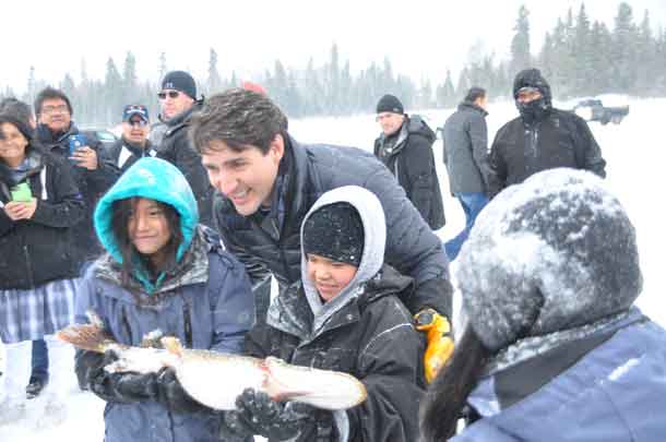 Prime Minister Trudeau poses with some successful fishers and their catch in Pikangikum First Nation