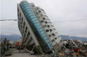 Rescue workers are seen by a damaged building after an earthquake hit Hualien, Taiwan February 7, 2018. REUTERS/Stringer