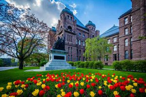 Tulips and statue outside the Legislative Assembly of Ontario, in Toronto, Ontario as the race to the June election heats up. Image Depositphotos.com