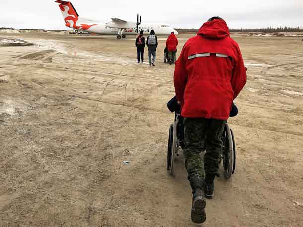 Canadian Rangers push elderly residents in wheelchairs to an evacuation plane in Kashechewan.