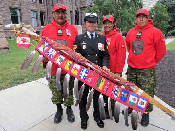 Sergeant Charlie Linklater, left, Master Corporal Emily Beardy, centre, and Corporal Terrence Duncan, right, with the Canadian Armed Forces eagle staff and its bearer.