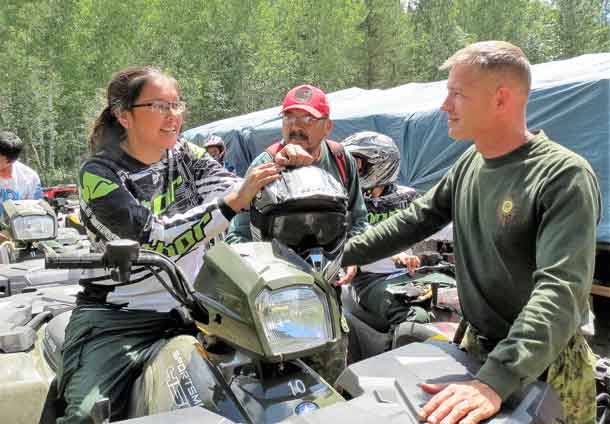 Sergeant Kevin Meikle goes over the parts of an ATV with a Junior Canadian Ranger.