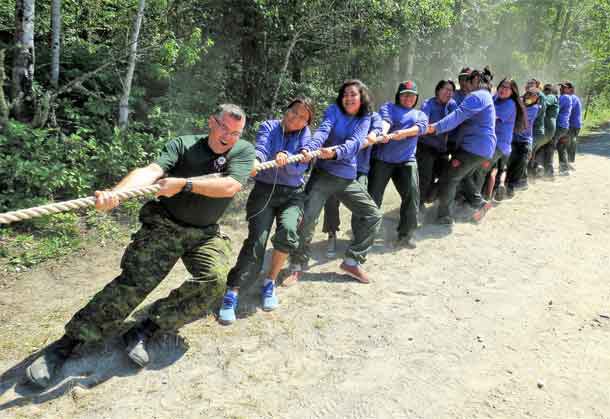 General Jocelyn Paul helps Junior Canadian Rangers win a tug of war contest against a team of soldiers.