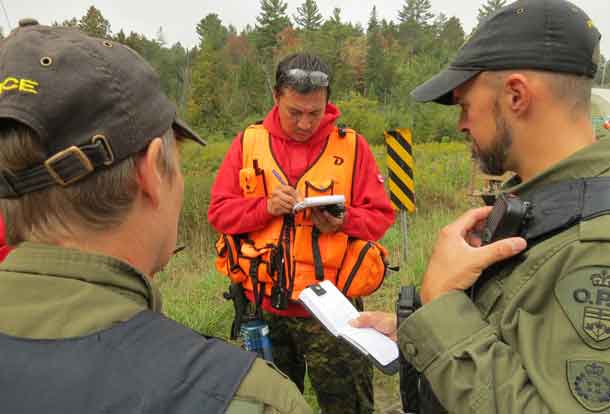 Master Corporal Shaun Kakegamic of Muskrat Dam take notes as OPP training officers give directions during a search and rescue exercise. credit Sergeant Peter Moon, Canadian Rangers