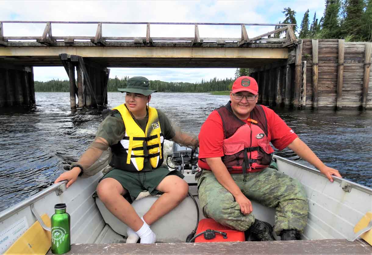 Junior Canadian Ranger Daniel Bottle, left, drives a safety boat with Corporal Ralph Winter of Wapekeke during boating training for Junior Rangers at Camp Loon.