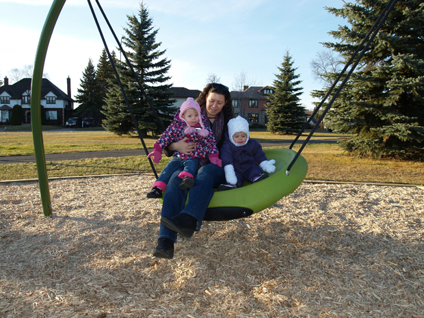 Jodi Wright with daughter Kaitlyn, 16 months, and friend Marlo Marasco, 14 months enjoy the new Oodle Swing at Hillcrest's new playground