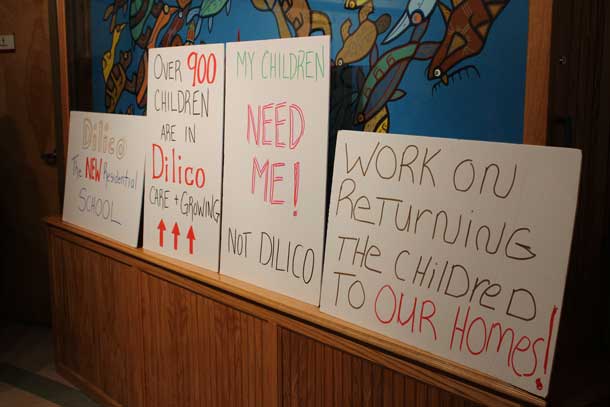 Family members put down their signs to talk with Dilico management