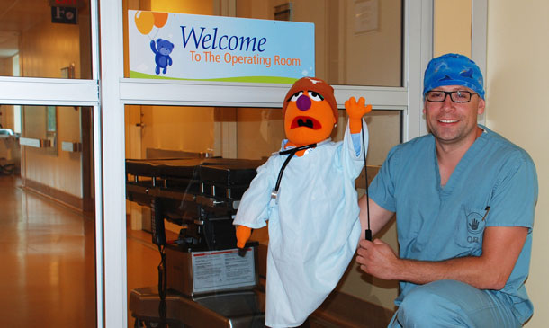Dave Vincent, RN shows off Sam Purple, an interactive puppet, who helps acquaint children with the Operating Room during a tour, prior to their visit for surgery.  Funding from a Family CARE Grant provided by the Thunder Bay Regional Health Sciences Foundation/Volunteer Association, allows children to bring home scrub-like pajamas after their tour finishes for a positive memory of the hospital