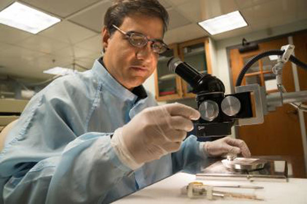 Using a binocular microscope, Dartmouth geochemist Mukul Sharma examines impact-derived spherules that he and his colleagues regard as evidence of a climate-altering meteor or comet impact 12,900 years ago. Photo Credit: Eli Burakian