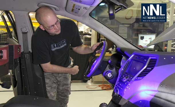 Mike Marvin from General Motors’ Competitive Benchmarking team uses a blue light scanner to capture precise 3-D images of a competitive vehicle interior. Complete sets of scans become reverse-engineered computer models for comparison to GM designs.