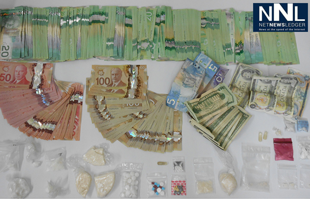 RCMP in Alberta show the cash and drugs seized in a raid in Grimshaw.