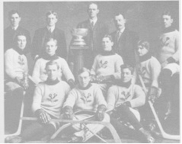 The Kenora Thistles’ Stanley Cup championship photograph.  Back row: team president Lowry Johnson, Russell Phillips, coach and trainer  J. A. Link, and team manager Red Hudson.   Middle row: Roxy Beaudro, Tom Hooper,  Tommy Phillips, Billy McGimsie, and Joe Hall.   Front row: Si Griffis, Eddie Giroux, and Art Ross.