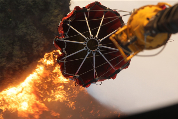 A CH-53E Super Stallion helicopter from Marine Heavy Helicopter Squadron 462, Marine Aircraft Group 16, 3rd Marine Aircraft Wing, collects water in a Bambi bucket during aerial firefighting efforts in California, May 14, 2014. Aircraft from the 3rd MAW are partnered with the California Department of Forestry and Fire Protection to conduct aerial firefighting against several wildfires ablaze in San Diego County. U.S. Marine Corps photo by Staff Sgt. Carl Atherton 