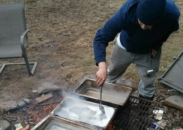 Stirring the sap to boil it down to the tasty maple syrup - Photo by Raili Alexander.